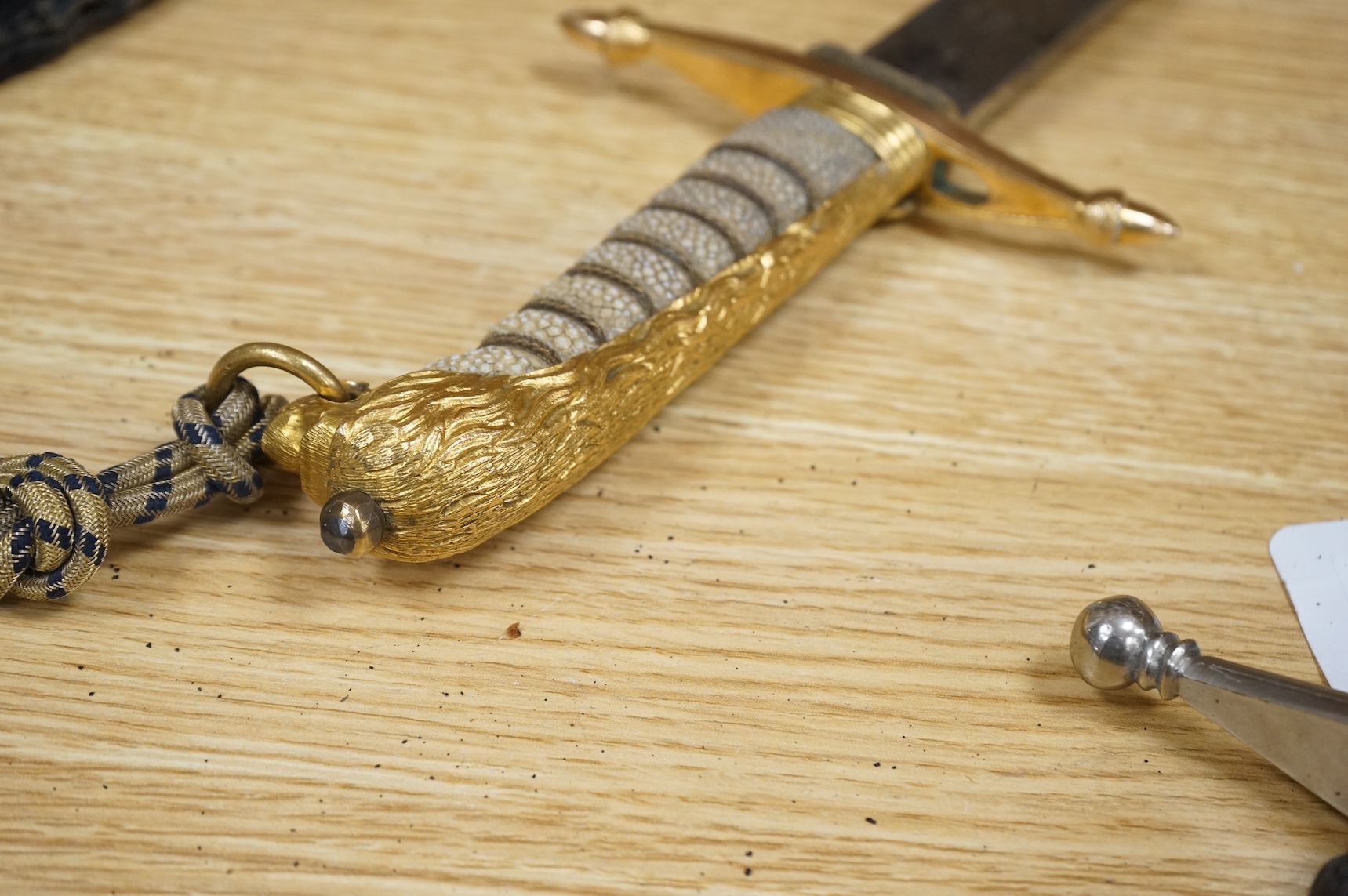 A post 1902 regulation Naval Officer’s dirk with lion’s head pommel, bullion dress knot, shark skin covered grip, in its leather scabbard, the gilt locket engraved with owners initials; CHCO’ R, the blade etched with cro